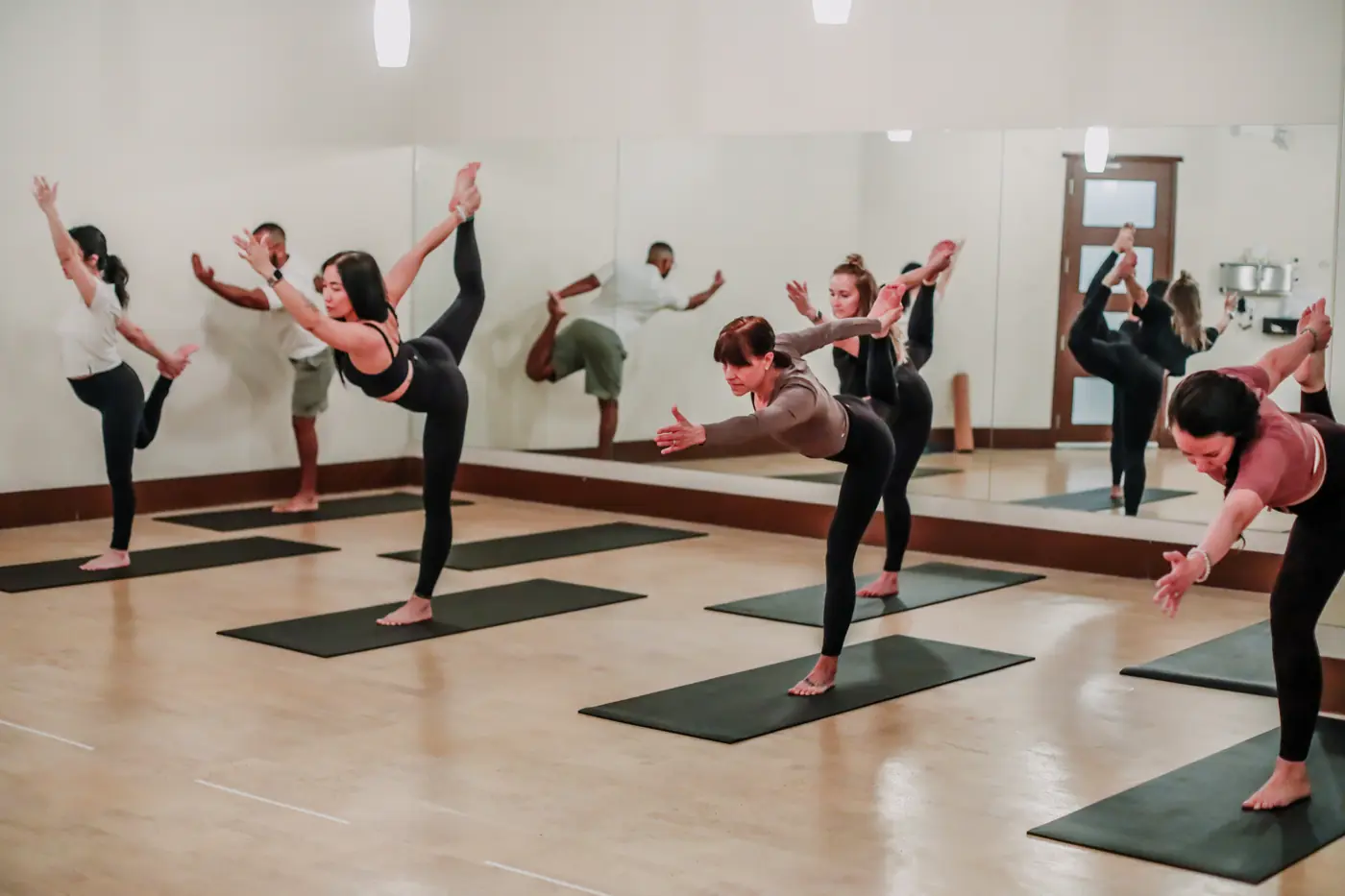 Students practising standing poses together in a Yogalife South class.